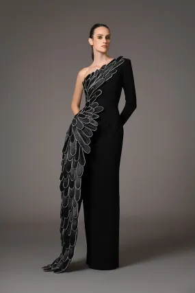 A sculpted gown in black silk crêpe paired with a winged cape of layered 3D hand-crafted plumes in scuba and crystals